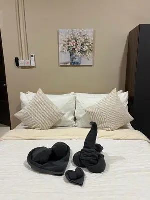 a stuffed animal sitting on top of a bed at Rumah No 5 in Taiping