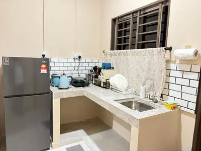 a kitchen with a sink and a refrigerator at Rumah No 5 in Taiping