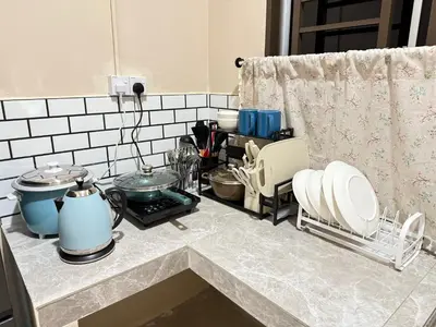 a kitchen counter with plates and utensils on it at Rumah No 5 in Taiping
