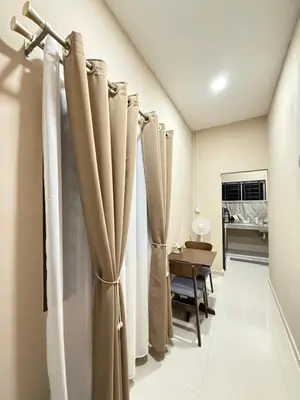a row of curtains in a room with a table at Rumah No 5 in Taiping