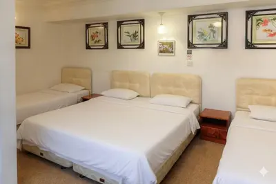a room with two beds and two chairs at Holiday Bungalow Guesthouse in Tanah Rata