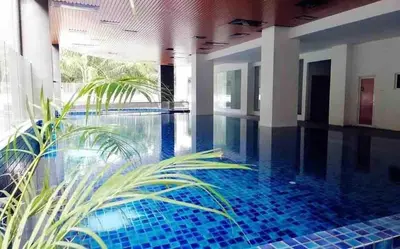 a swimming pool with a blue tile floor and a plant at The Venus Sweet home in Sitiawan
