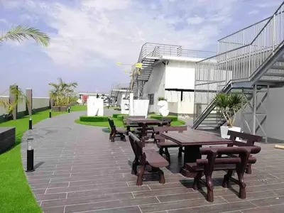 a patio with wooden tables and chairs and grass at The Venus Sweet home in Sitiawan
