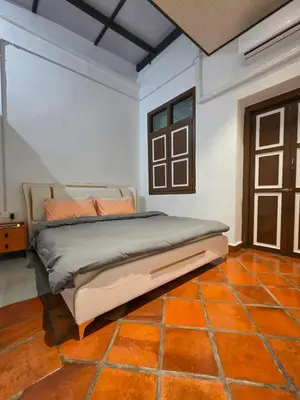 a bedroom with a bed with an orange tile floor at New ! 6 Pax Georgetown Heritage Pre-war House 2 Bed Room in George Town