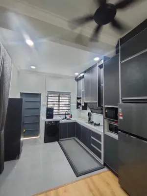 a kitchen with stainless steel appliances and black cabinets at Homestay Saujana Hill in Gua Musang