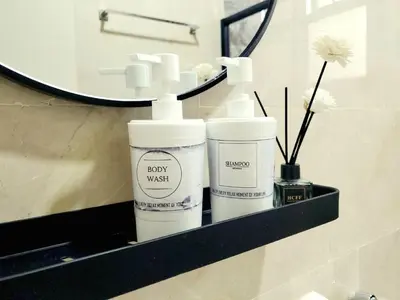 a bathroom shelf with two bottles of soap and a mirror at Ipoh Cove Hillside Mini Waterpark Family Suite in Ipoh