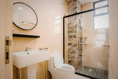 a bathroom with a toilet and a sink and a mirror at Ipoh Cove Hillside Mini Waterpark Family Suite in Ipoh