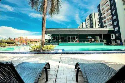 a swimming pool with two chairs in front of a building at Ipoh Manhattan Free Waterpark 3BR 8Pax Family Suite MHA306 by City Home Empire in Ipoh