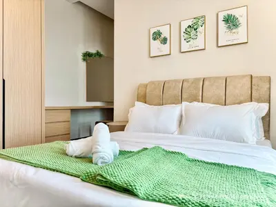 a bed with a green blanket and pillows on it at D'Festivo Residence Ipoh 3Bdr by PLY Home in Ipoh