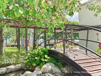 a wooden bridge over a walkway in a park at D'Festivo Residence Ipoh 3Bdr by PLY Home in Ipoh