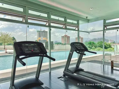 a gym with two exercise bikes in front of a window at D'Festivo Residence Ipoh 3Bdr by PLY Home in Ipoh