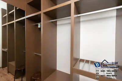 a walk in closet with wooden shelves and a window at Jambul Residence 15 in Gua Sai
