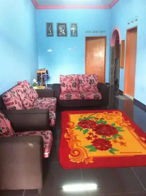 a living room with two couches and a colorful rug at Homestay bonda tanjung malim in Kampong Keteyong