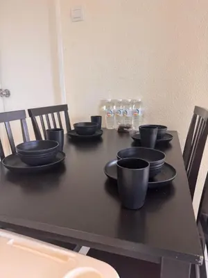 a black table with black cups and plates on it at Sri Sayang sunset 2 bedroom in Batu Ferringhi