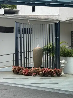 a gate with a bunch of flowers and a vase at Sri Sayang sunset 2 bedroom in Batu Ferringhi