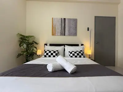 a bedroom with a white bed with black and white pillows at Cozy 3BR Emerald Avenue Brinchang, 8pax Netflix in Brinchang