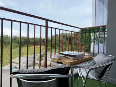 a table and two chairs on a balcony at Cozy 3BR Emerald Avenue Brinchang, 8pax Netflix in Brinchang