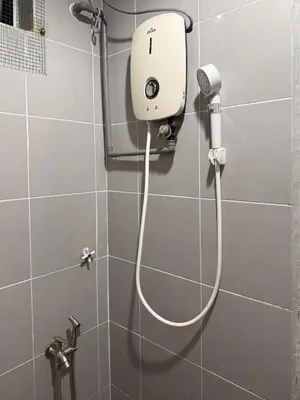 a shower with a hair dryer in a bathroom at Cozy Inn Homestay in Kampar