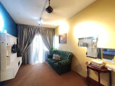 a living room with a green couch and a window at ZE I Cameron Jaya, Tanah Rata in Tanah Rata