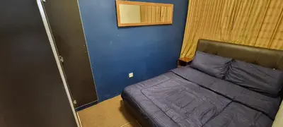 a bed in a room with a blue wall at ZE I Cameron Jaya, Tanah Rata in Tanah Rata