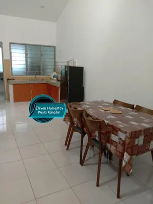 a kitchen with a table and chairs and a refrigerator at Eleven Homestay Kuala Kangsar in Kuala Kangsar