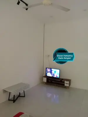 a living room with a tv and a table at Eleven Homestay Kuala Kangsar in Kuala Kangsar