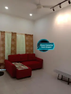 a living room with a red couch and a sign at Eleven Homestay Kuala Kangsar in Kuala Kangsar