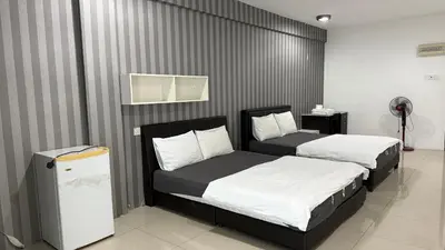 a bedroom with two beds and a refrigerator at Summer Hotel Kampar Perak in Kampar