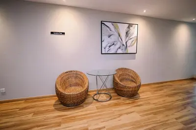 two chairs and a table in a room with a painting at Kingston Hotel 15 - Tower Regency, Ipoh in Ipoh