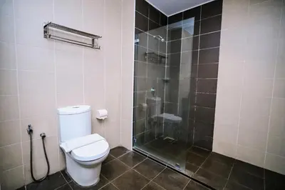 a bathroom with a toilet and a glass shower at Kingston Hotel 15 - Tower Regency, Ipoh in Ipoh