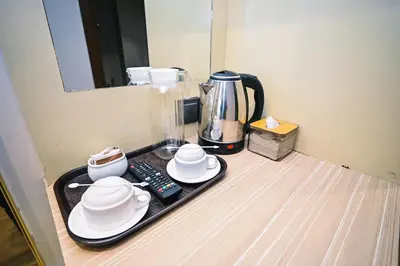 a tray with dishes and a coffee maker on a counter at Kingston Hotel 15 - Tower Regency, Ipoh in Ipoh