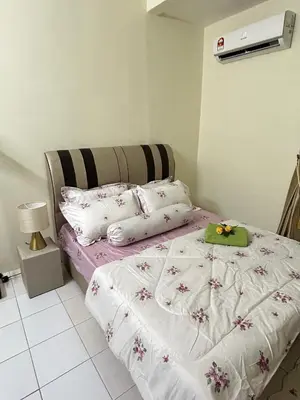 a bedroom with a bed with white sheets and pillows at Mumtaz Homestay in Kampong Belah Dua