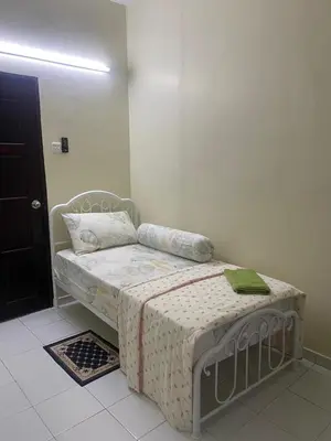 a small bed in a room with a white floor at Mumtaz Homestay in Kampong Belah Dua