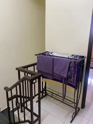 a drying rack with purple sheets on it in a room at Mumtaz Homestay in Kampong Belah Dua