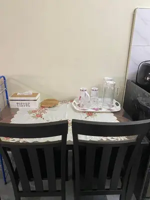 a table with two chairs and two plates and glasses at Mumtaz Homestay in Kampong Belah Dua