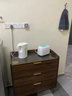 a wooden dresser with a wii on top of it at Mumtaz Homestay in Kampong Belah Dua