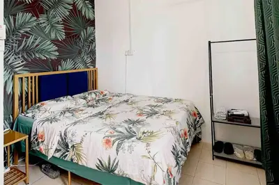 a bedroom with a bed with a floral bedspread at Cozy Private Room Teluk Intan in Teluk Intan