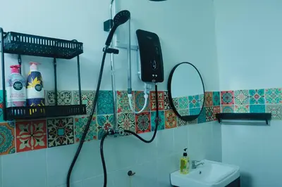 a bathroom with a shower and a sink and a mirror at Cozy Private Room Teluk Intan in Teluk Intan