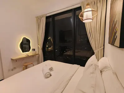 a bedroom with a white bed with a large window at Urban Suites Georgetown Penang - Affordable & Cozy Stay with High Floor-Sea & Penang Bridge View in George Town