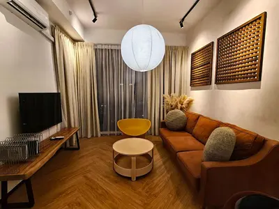 a living room with a brown couch and a tv at Urban Suites Georgetown Penang - Affordable & Cozy Stay with High Floor-Sea & Penang Bridge View in George Town