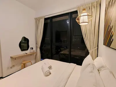 a bedroom with a white bed and a large window at Urban Suites Georgetown Penang - Affordable & Cozy Stay with High Floor-Sea & Penang Bridge View in George Town