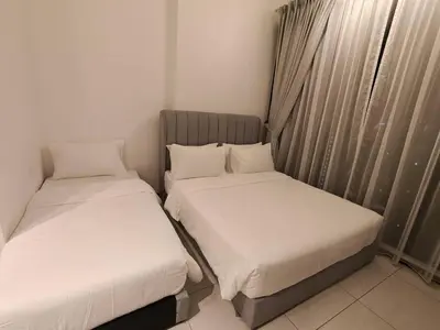 two beds sitting next to each other in a room at Urban Suites Georgetown Penang - Affordable & Cozy Stay with High Floor-Sea & Penang Bridge View in George Town
