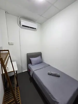 a small room with a bed with a pillow and a heater at The Ipohstay hostel in Ipoh