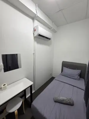 a small room with a bed and a desk and a tv at The Ipohstay hostel in Ipoh