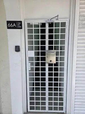 a door with a gate with a sign on it at The Ipohstay hostel in Ipoh