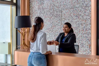 two women shaking hands at a counter in a store at 22 Macalisterz by ALV in George Town