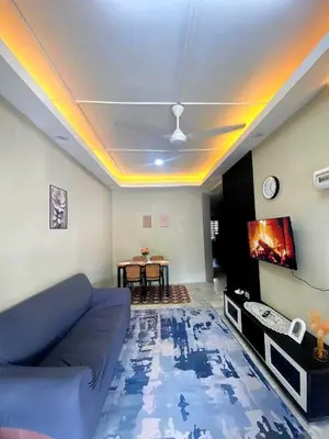 a living room with a blue couch and a table at Homestay Bonda E in TanjongMalim