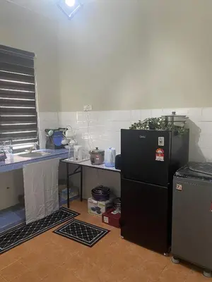 a kitchen with a black refrigerator and a sink at Homestay Bonda E in TanjongMalim