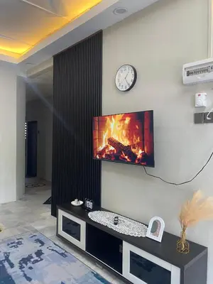 a living room with a fire on the wall at Homestay Bonda E in TanjongMalim