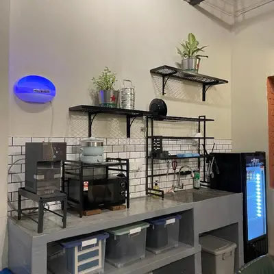 a kitchen with shelves on the wall with plants at Miner's House Ipoh in Ipoh